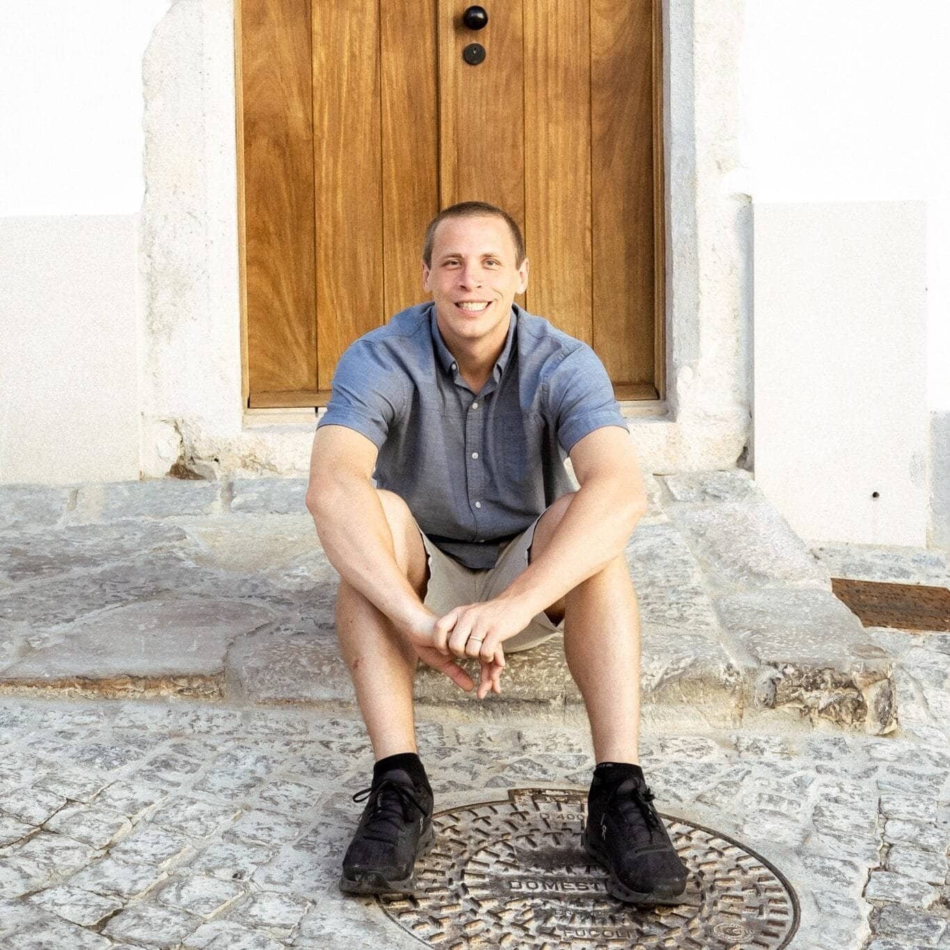 Justin Rittenhouse sitting down in Portugal on a stone step.